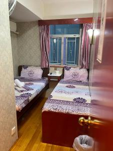 een kamer met 2 bedden en een raam bij United Co-Operate Guest House (7/F) in Hong Kong