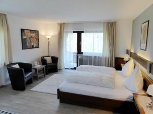 a hotel room with a bed and a chair at Landhotel Rebstock in Oberkirch