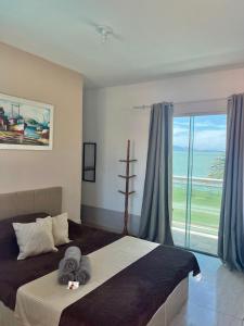 1 dormitorio con 1 cama con toallas en Suítes Brandi en Arraial do Cabo
