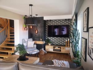 uma sala de estar com um sofá e uma televisão em Glam Design - Beautiful, comfortable and cosy house with garden, free parking and WIFI na Cracóvia