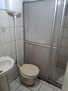 a bathroom with a shower with a toilet and a sink at Quarto privativo, banheiro externo. in Novo Hamburgo