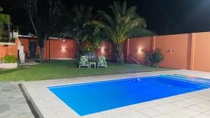a swimming pool in a yard with two chairs and a fence at Tupungato Village in Tupungato