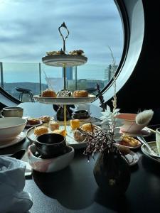 einen Tisch mit Teller mit Lebensmitteln auf einem Tisch mit einem Fenster in der Unterkunft Christchurch City Hotel in Christchurch