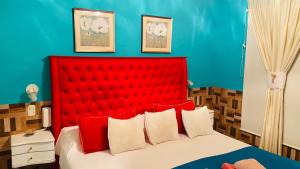 une chambre avec une tête de lit rouge et un mur bleu dans l'établissement Tupungato Village, à Tupungato
