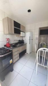 cocina con fogones, nevera y mesa en FLAT FAMILIAR com garagem até 5 pessoas, en Campina Grande