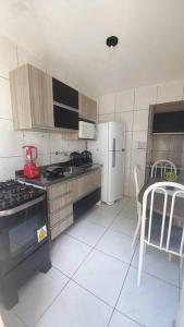 a kitchen with a stove and a refrigerator and a table at Flat com garagem para até 5 pessoas in Campina Grande