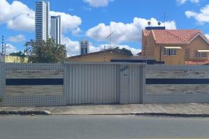 a fence with a gate in front of a house at Flat com garagem para até 5 pessoas in Campina Grande