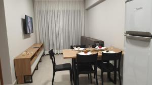 uma sala de jantar com uma mesa e cadeiras pretas em UNNAVENTURA VILA ATLÂNTIDA em Luís Correia