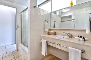 Whitsunday Apartments on Hamilton Island by HIHA في جزيرة هاميلتون: حمام مع حوض ومرآة