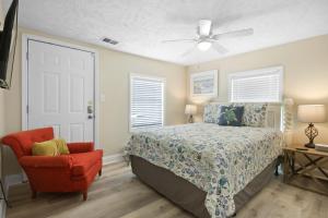 una camera con letto, sedia e ventilatore a soffitto di Blueberry Wine a Myrtle Beach