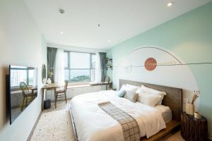 een slaapkamer met een groot bed en een bureau bij THE SONG VŨNG TÀU - Five-Star Luxury Apartment - Căn Hộ Du Lịch 5 Sao Cạnh Biển in Vung Tau