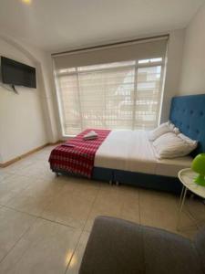 1 dormitorio con cama y ventana grande en ApartaSuites Bogota Campin, en Bogotá