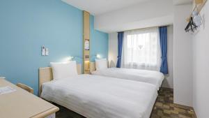 Postel nebo postele na pokoji v ubytování Toyoko Inn Chigasaki Shiyakusho
