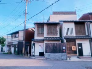 una casa blanca con una puerta en una calle en 桃夭庵 touyouan momo house kujo 一棟貸切, en Kioto