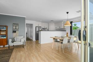 a kitchen and dining room with a table and chairs at Beltana - Aldinga Beach - C21 SouthCoast Holidays in Aldinga Beach