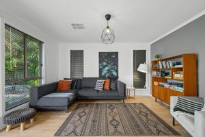 - un salon avec un canapé gris et un tapis dans l'établissement Beltana - Aldinga Beach - C21 SouthCoast Holidays, à Aldinga Beach 24 autres photos