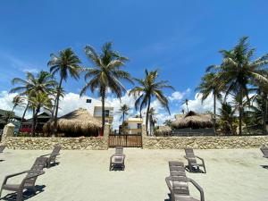 - une plage avec des chaises, des palmiers et des palmiers dans l'établissement Apartamento en condominio con vista al mar, à San Bernardo del Viento