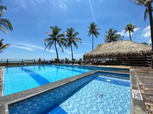 une piscine avec des palmiers en arrière-plan dans l'établissement Apartamento en condominio con vista al mar, à San Bernardo del Viento