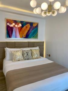 a bedroom with a bed with a painting on the wall at MAKATI Isabela Luxury in Manila