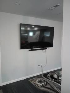 a flat screen tv hanging on a white wall at Nice & Near Downtown Nashville in Nashville