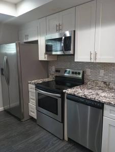 a kitchen with stainless steel appliances and white cabinets at Nice & Near Downtown Nashville in Nashville