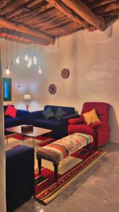 a living room with blue and red couches and a table at السبعينات - السودة Seventies -Al-Sodah in Suda