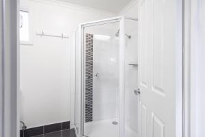 a shower with a glass door in a bathroom at Graham Apartments in Hobart +90 photos