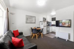 a living room with a couch and a table and a kitchen at Graham Apartments in Hobart