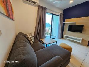 a living room with a couch and a tv at Hotspring 2 Room Premium 1510 Suite Sunway Onsen Theme Park View, 5pax in Ipoh