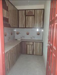 una cocina con armarios de madera y una puerta roja en Saspolo chain of G house, en Skardu