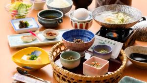 a table topped with bowls and plates of food at Tamaya Ryokan in Ueda