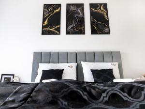 a bedroom with a bed with four pictures on the wall at Apartment by Dziwna River with Pool Access in Dziwnów +21 photos