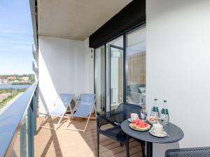 a balcony with a table with drinks and food on it at Apartment with swimming pool, sauna, whirlpool, Dziwnów in Dziwnów