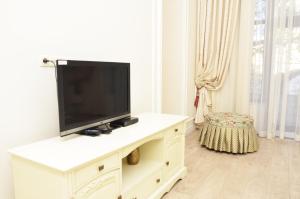 a television on a white cabinet in a living room at Hotel Menshikov in Odesa