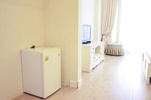 a white refrigerator in a room with a television at Hotel Menshikov in Odesa