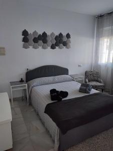 een slaapkamer met een bed met twee schoenen erop bij VG UN POQUITO DE TI in El Puerto de Santa María