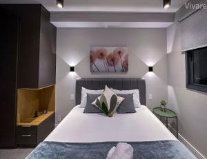 een slaapkamer met een groot wit bed met een plant erop bij Paradise Frei Caneca in Sao Paulo