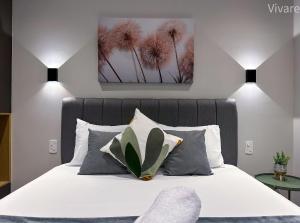 een slaapkamer met een bed met witte lakens en palmbomen bij Paradise Frei Caneca in Sao Paulo