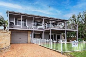 una casa con una valla blanca delante en Bay Vista, en Quindalup
