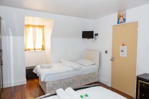 Una cama o camas en una habitación de Heathrow Garden House - West Drayton, London - Benjamin Guest House
