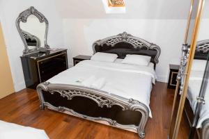 1 dormitorio con 1 cama grande y espejo en Benjamin Guest house, en Yiewsley