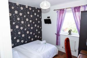 a bedroom with a black and white floral wall at Benjamin Guest house in Yiewsley