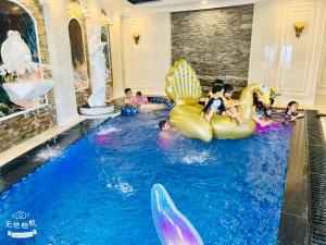 Phúc YênにあるL'ama Villa Đại Lải - Venuestayの屋内スイミングプールで遊ぶ子供のグループ