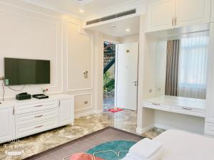 Phúc YênにあるL'ama Villa Đại Lải - Venuestayの白いリビングルーム(テレビ、テーブル付)