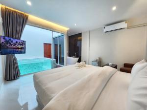 a bedroom with a large bed and a swimming pool at PVILLA in Ban Phraek Sa