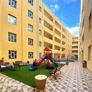 a playground in the courtyard of a building at مجمع الحديقة in Salalah
