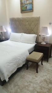 a bedroom with a large bed and a table with a lamp at مجمع الحديقة in Salalah