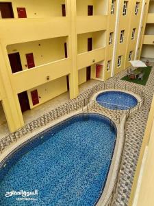 an overhead view of a large building with a swimming pool at مجمع الحديقة in Salalah