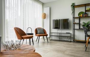 sala de estar con 2 sillas y TV en Beautiful Home In Vlagtwedde With House Sea View, en Vlagtwedde