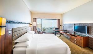 um quarto de hotel com uma cama e uma televisão de ecrã plano em Royal Orchid Sheraton Hotel and Towers em Banguecoque
